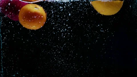 Three fruits dropping in to the water same time and splashing in back backgr Stock Footage 159613125