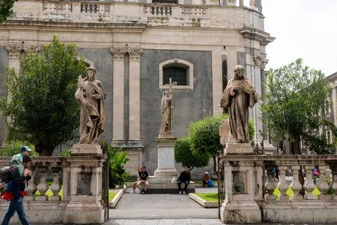 Three garden statues in front of stone church wall 스톡 사진