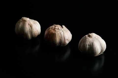Three garlics on a black table. High quality Stock Photos