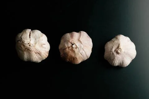 Three garlics on a black table. High quality Stock Photos