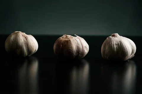 Three garlics on a black table. High quality Stock Photos