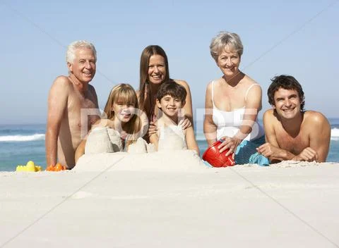 Three Generation Family Building Sandcastles On Beach Holiday Stock Photos