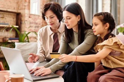 Three generation family of females in smart casualwear shopping at home Stock Photos