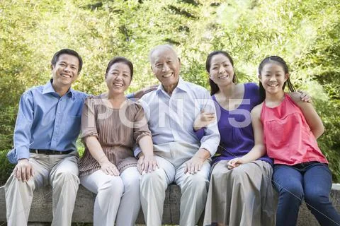 Three Generation Family Sitting in their Apartment Courtyard Stock Photos
