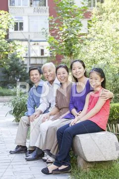 Three Generation Family Sitting in their Apartment Courtyard Stock Photos