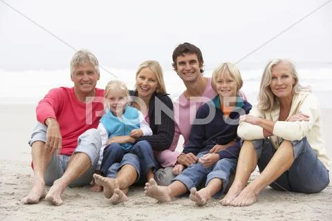 Three Generation Family Sitting On Winter Beach Together Stock Photos