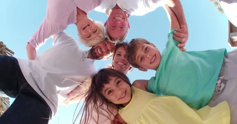 Three generation family standing in a circle smiling Stock Footage