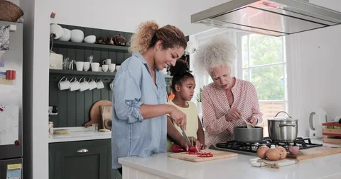 Three generations of family cooking a meal together Stock Footage