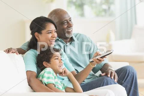 Three Generations Of Family Watching Tv