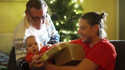 Three generations of the same family, a grandson, a son and a father unpack a Stock Footage 98558391