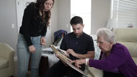 Three Generations Share Memories While Looking Through a Family Album Stock Footage 306848735