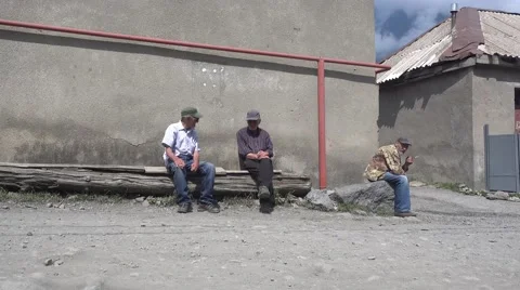 Three Georgian men sitting in the sun with sunglasses and smoking cigarettes Stock Footage 66581404