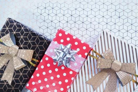 Three gift boxes are black-gold with a gold bow, red to white peas with a sil Stock Photos