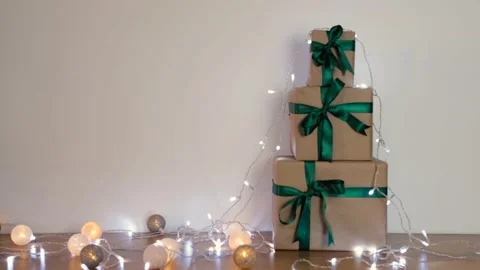 Three gift boxes with green ribbons decorated with light. Vídeo Stock 142075987