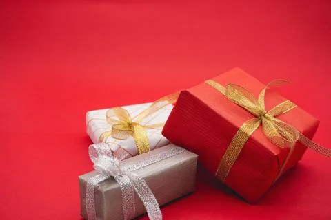 Three gift boxes, red, gray and white. Close up on a red background. 写真素材
