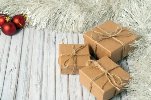 Three gift boxes on a wooden table decorated with a garland and red Christmas Stock Photos