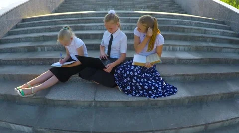 Three girl students doing lessons on the steps 库存影片 51604666
