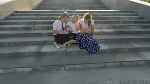 Three girl students doing lessons on the steps and eat ice cream. Video stock 51604824
