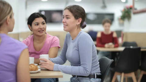 Three girlfriends drinking coffee and chatting Stock Footage 330040211