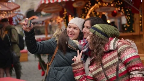 Three Girlfriends Taking a Selfie with Smart Phone on the Christmas Market Stock Footage 70229207