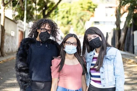 Three girlfriends using face mask and walking Foto stock