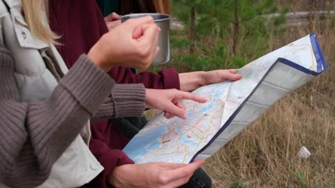 Three girls are reading map. Friends are traveling by car in the forest. Stock Footage 254289595