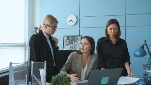 Three girls are talking about business in their office and checking documents Stock Footage 130868086