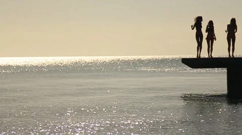 Three girls in bathing suit dancing on the pier Stock Footage 58913530