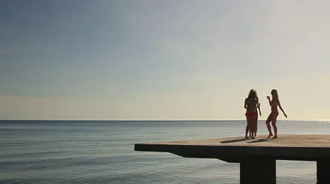 Three girls in bathing suit dancing on the pier Stock Footage 58913539