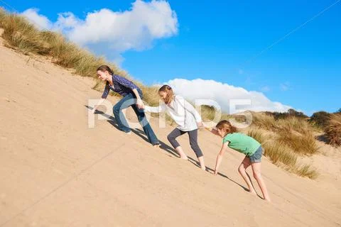 Three Girls Climbing Up Sand Dune