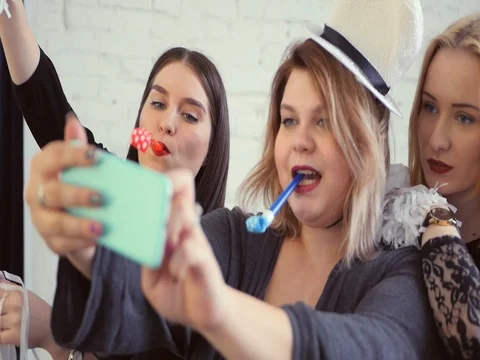Three girls having fun, doing selfie, celebrating holiday, jumping and laughing Stock Footage 73938500