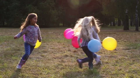 Three girls having fun running in the park with balloons Stock Footage 55091922