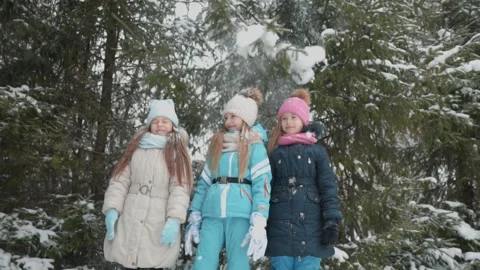 Three girls stand under a tree with snow falling on them. Stock Footage 144322546