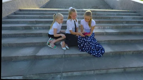 Three girls students do self on the steps and laugh. 库存影片 51604732