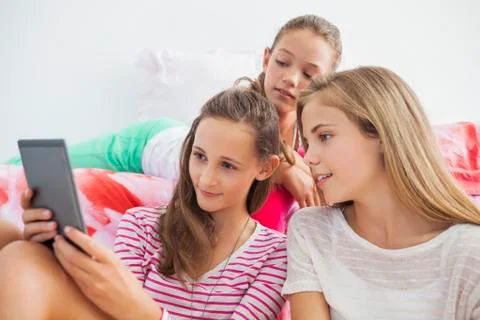 Three girls using a digital tablet at a slumber party Stock Photos