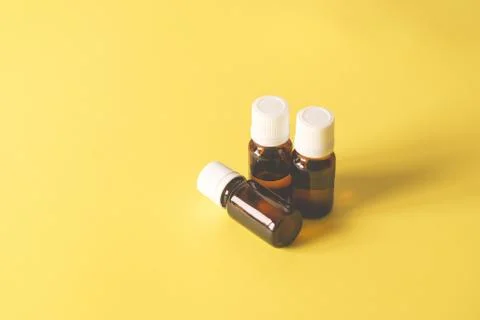 Three glass bottles on a yellow background Stock Photos