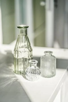 Three glass vases on the table in the interior of the house. Stock Photos