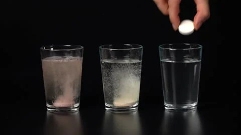 Three glasses on a black background with colored water with bubbles from Stock Footage 202648542