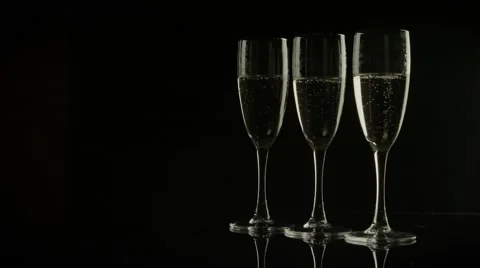 Three glasses of champagne on black background Stock Footage 56637598