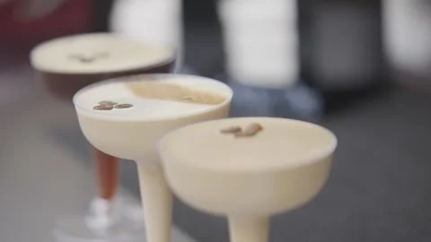 Three glasses of different colored drinks with a brown foam on top Stock Footage 301629404