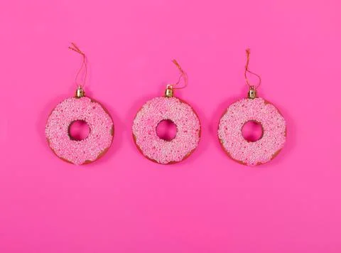 Three glasses donuts on pink background. Christmas toy: pink donats. Stock Photos