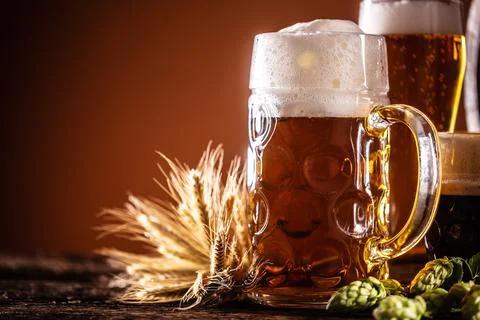 Three glasses with draft beer in front of a wooden barrel. Decoration of ba.. Stock Photos