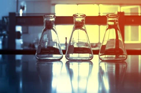 Three glasses flask on chemistry science laboratory blue background Stock Photos