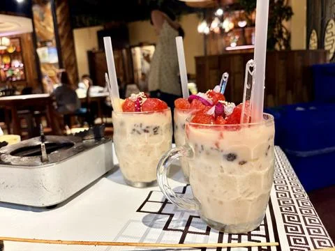 Three glasses of fruit and milk dessert on a table. Stock-Fotos