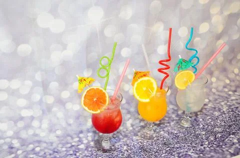 Three glasses with orange, lime and grapefruit juice, decorated with straws, Stock Photos