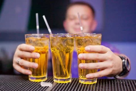 Three glasses with a refreshing drink on bar counter Stock Photos