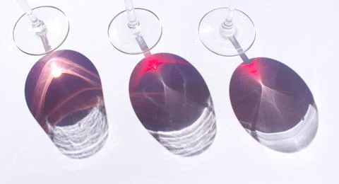 Three glasses of wine: red and pink on white background with sparkling shadow Stock Photos