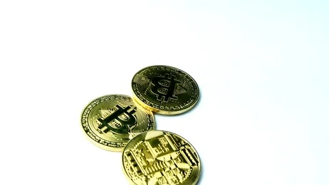 Three gold BTC bitcoin crypto currency spun on white surface, spinning coin Stock Footage 85685579