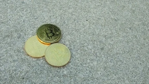 Three gold coins of bitcoin on the grey asphalt. Stock Footage 84331512