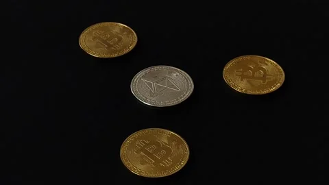 Three golden bitcoins around a silver ethereum on a rotating black surface Stock Footage 209901239